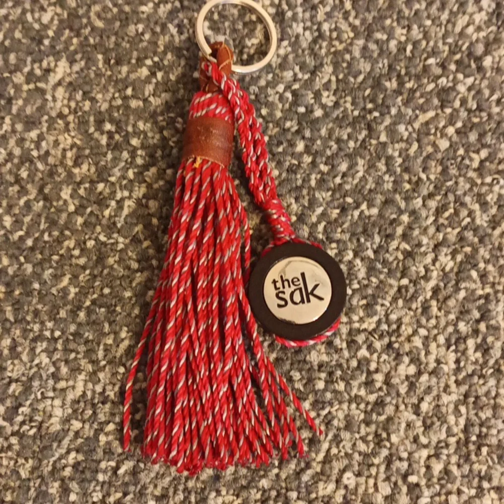The Sak red and brown leather keychain the Sak emblem